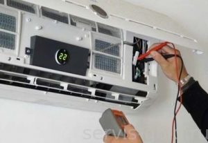 Τεχνικός συντηρεί ανοιχτή εσωτερική μονάδα κλιματιστικού