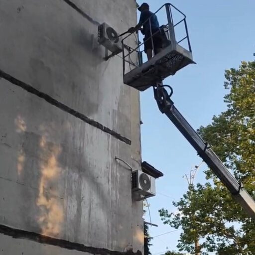 Τεχνικός σε ανυψωτικό εργάζεται σε εξωτερική μονάδα κλιματιστικού